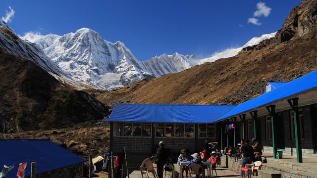 Trekkers on the trail to Annapurna Base Camp with snow peaks behind — a short, affordable Nepal trek popular with Indian travellers