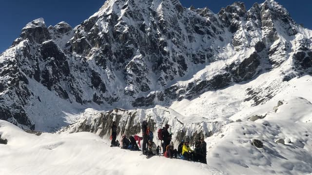 A mountaineer high on a snow-covered Himalayan ridge in the Everest region, illustrating the extreme high-altitude terrain that makes Everest deadly