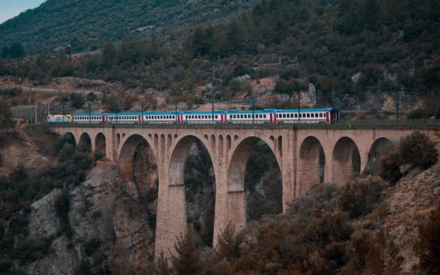 Passenger train railway viaduct mountain scenery — illustrating The World's 12 Most Spectacular Train Journeys for