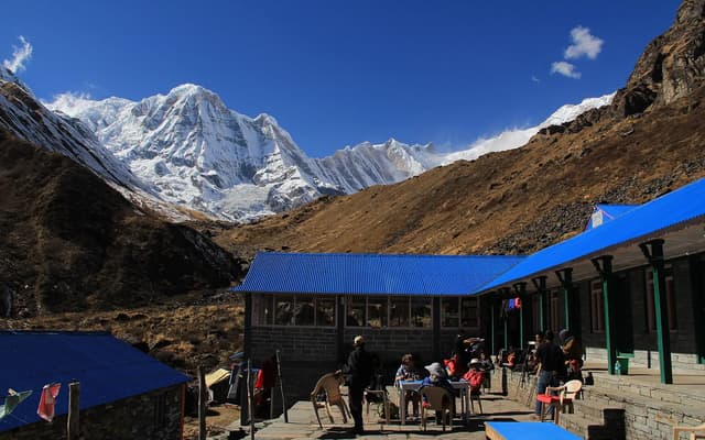 Trekkers on the trail to Annapurna Base Camp with snow peaks behind — a short, affordable Nepal trek popular with Indian travellers