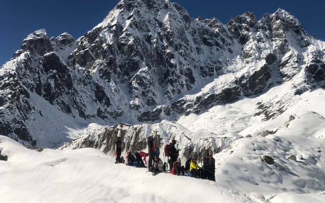 A mountaineer high on a snow-covered Himalayan ridge in the Everest region, illustrating the extreme high-altitude terrain that makes Everest deadly