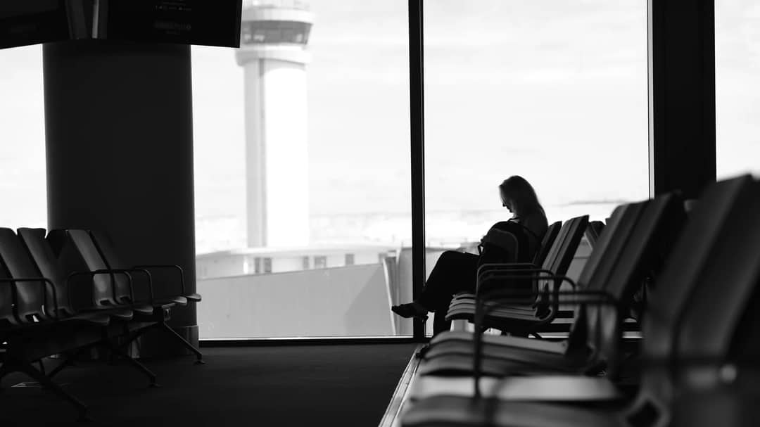 A traveller waiting in an airport lounge beside a window