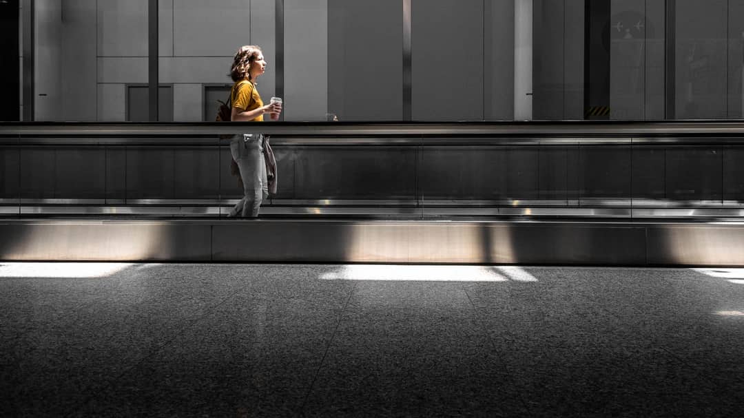 A traveller walking through a bright, airy terminal at a Toronto airport