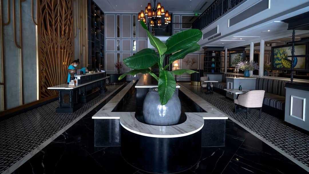 A luxurious hotel lobby with a chandelier and sleek modern decor