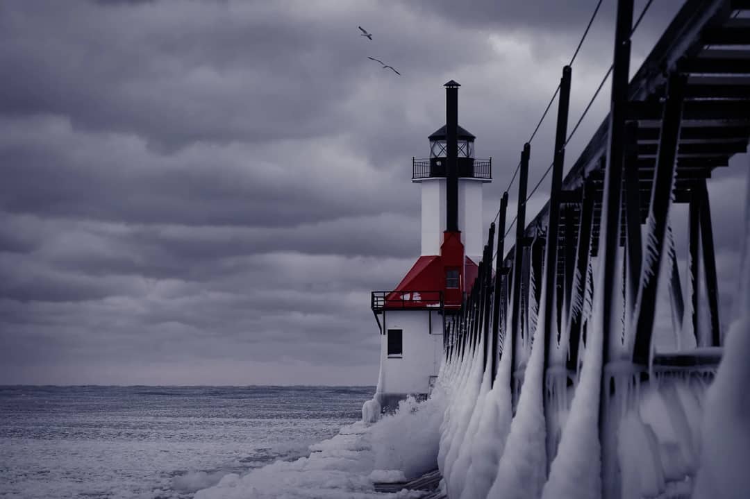 A lighthouse at the end of a pier on Lake Michigan