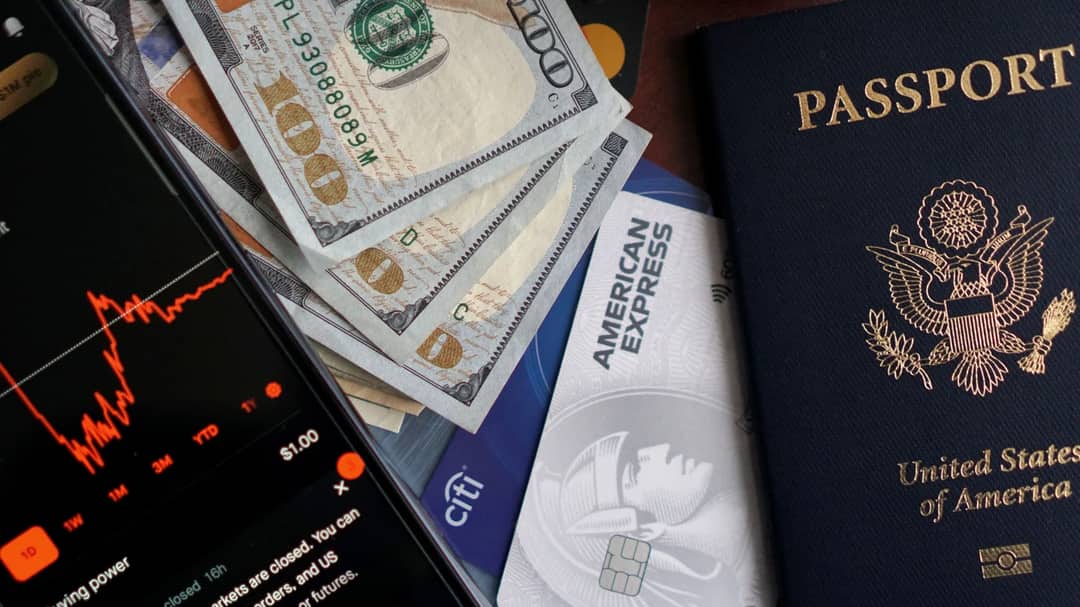 A passport, bank cards and cash laid out on a table before a trip