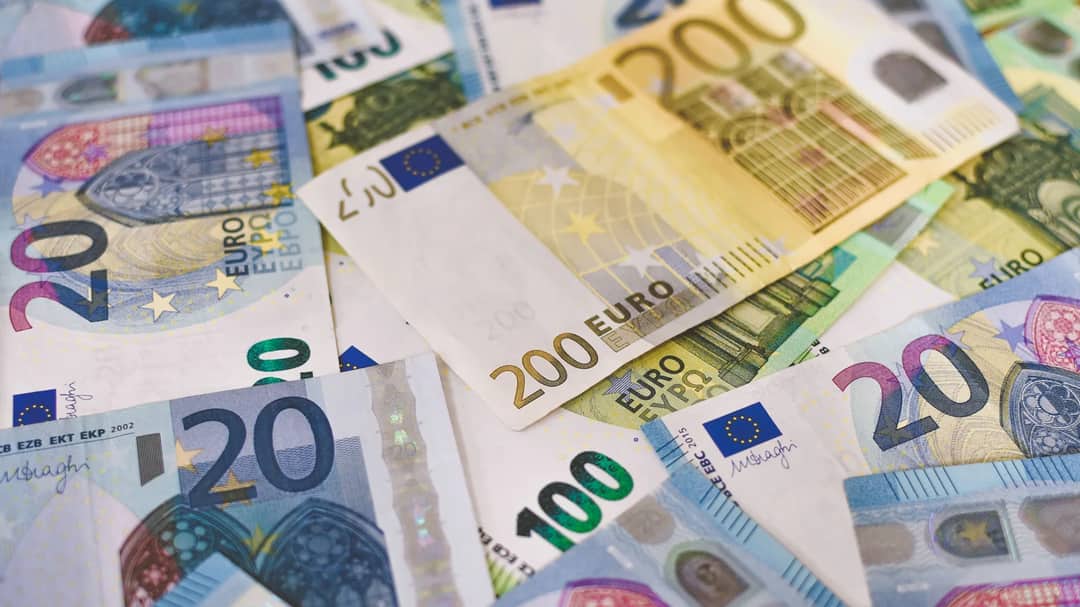 Close-up of assorted euro banknotes spread across a surface