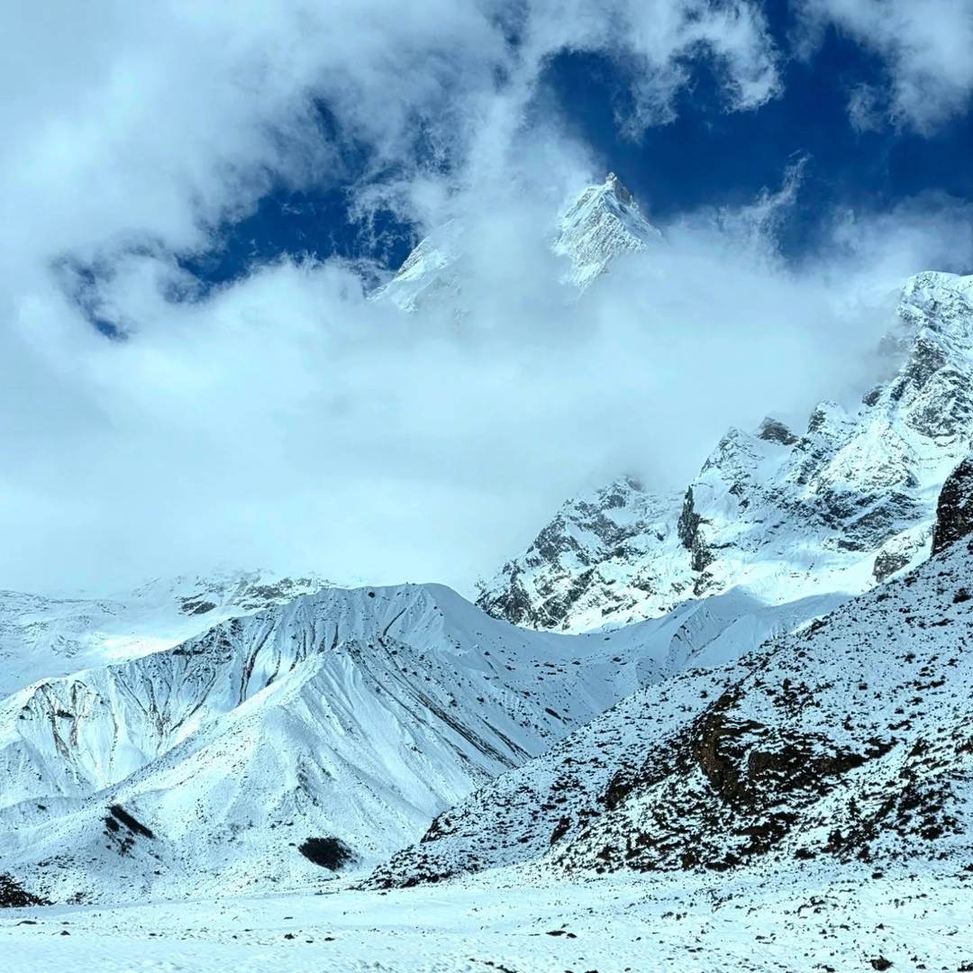 Snow-covered high valley and cloud-wrapped peaks above 4,000m on the Manaslu Circuit in Nepal