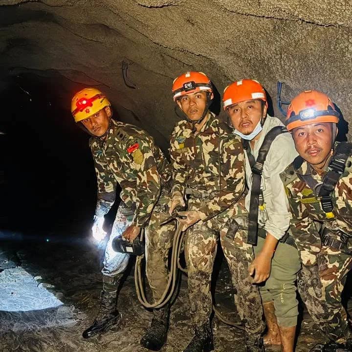 Rescue workers in helmets and headlamps in the flooded hydropower tunnel