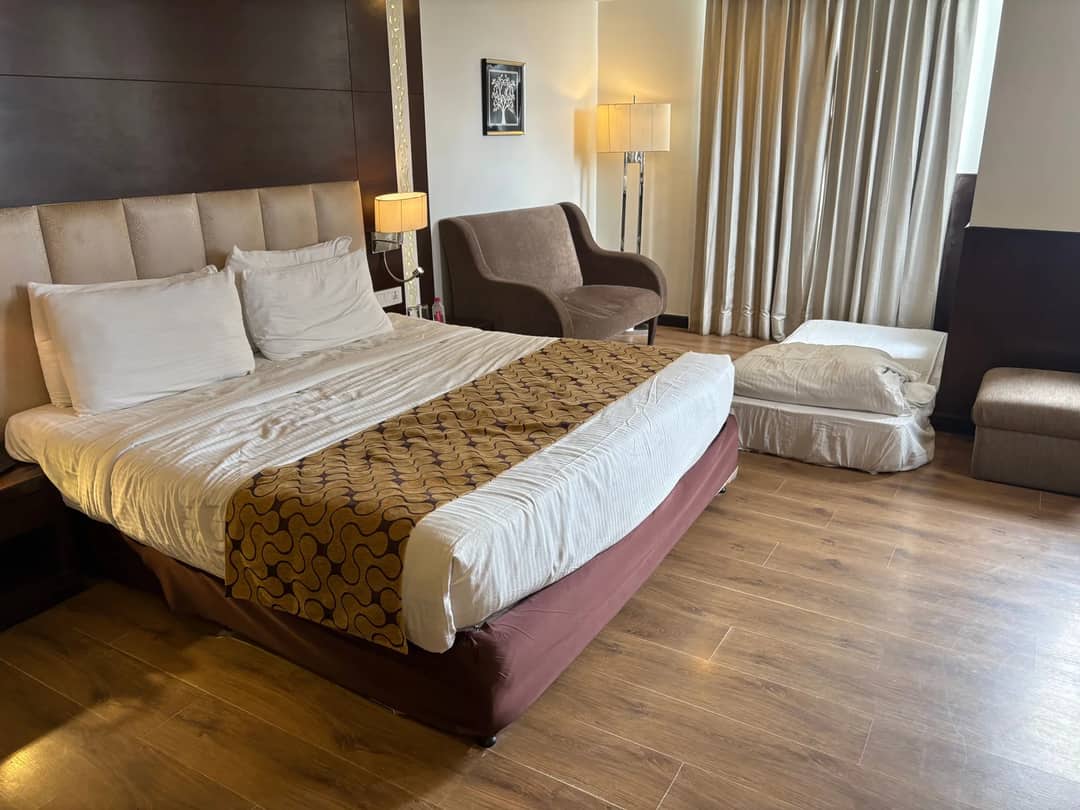 A hotel room with a made bed