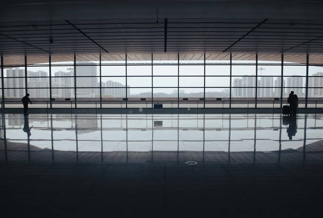 Two travellers in a near-empty airport terminal