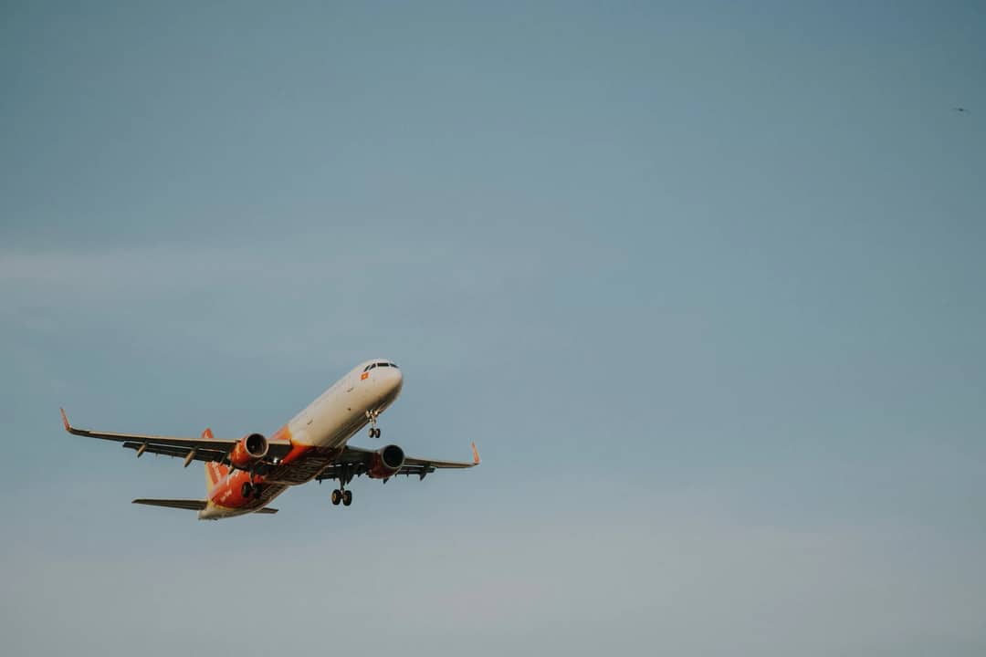 Commercial airplane flying high in a clear blue sky, capturing a moment of aviation travel.