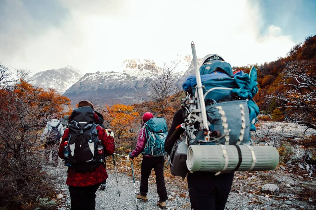 Trekkers walking a mountain trail with full packs