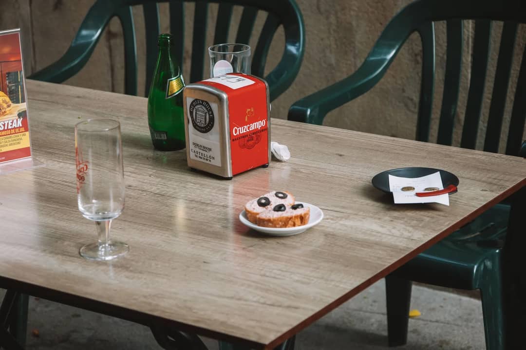 A cafe table with a drink and a pastry