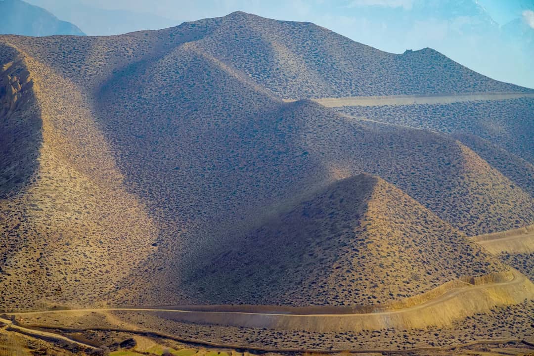 Breathtaking landscape of the arid hills in Upper Mustang, Nepal, under a clear sky.
