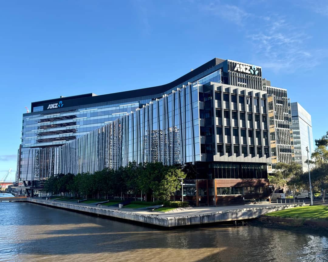 A sleek modern office building in Docklands, Melbourne, Australia with reflective glass facade.