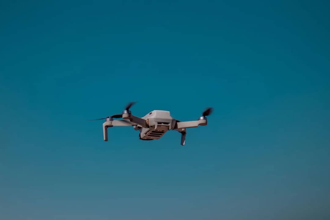 Aerial drone flying in the open sky on a clear day, showcasing modern technology.