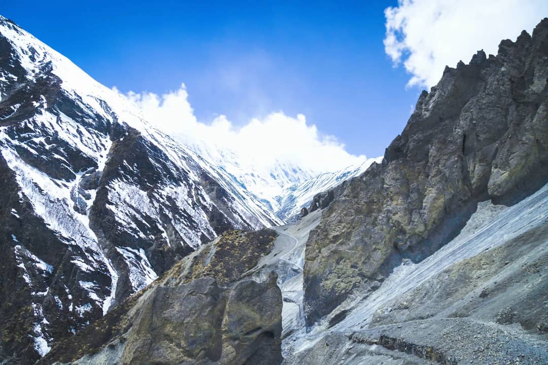 Breathtaking view of snow-capped peaks in Manang, Nepal, under a clear blue sky.