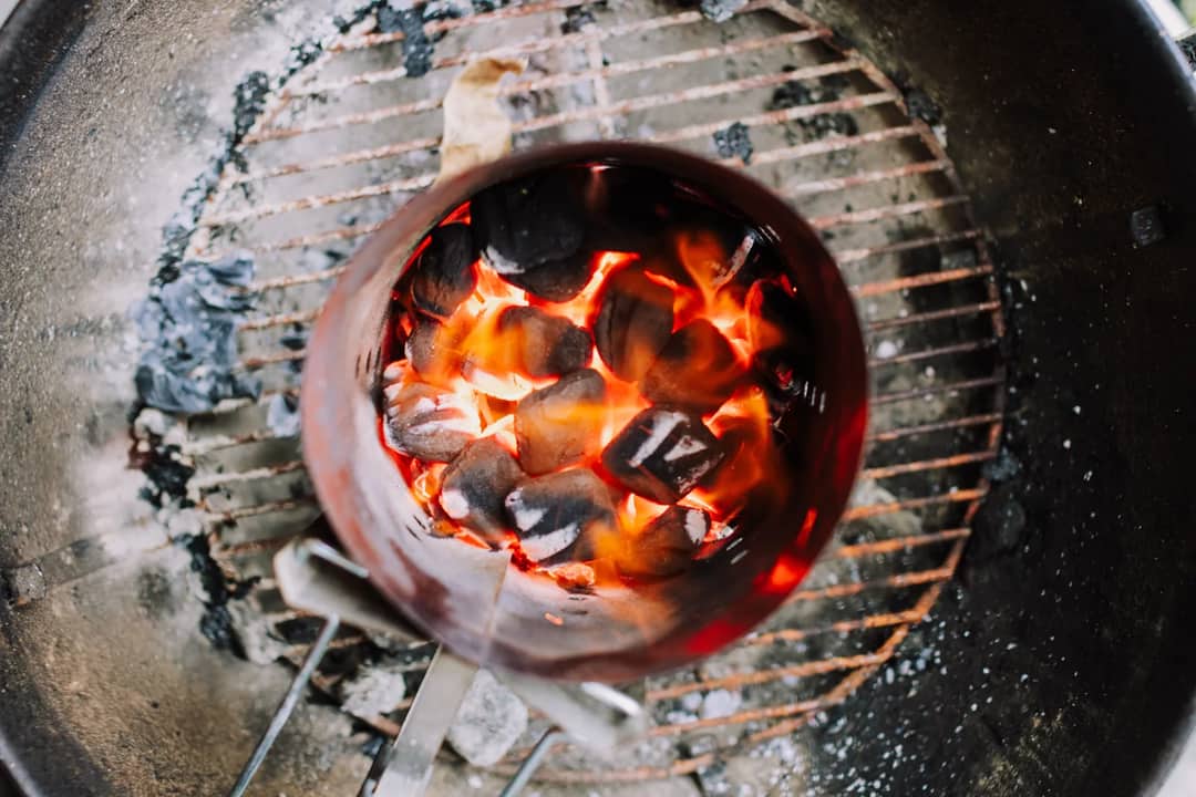 Top view of burning charcoal briquettes in a grill, perfect for BBQs.