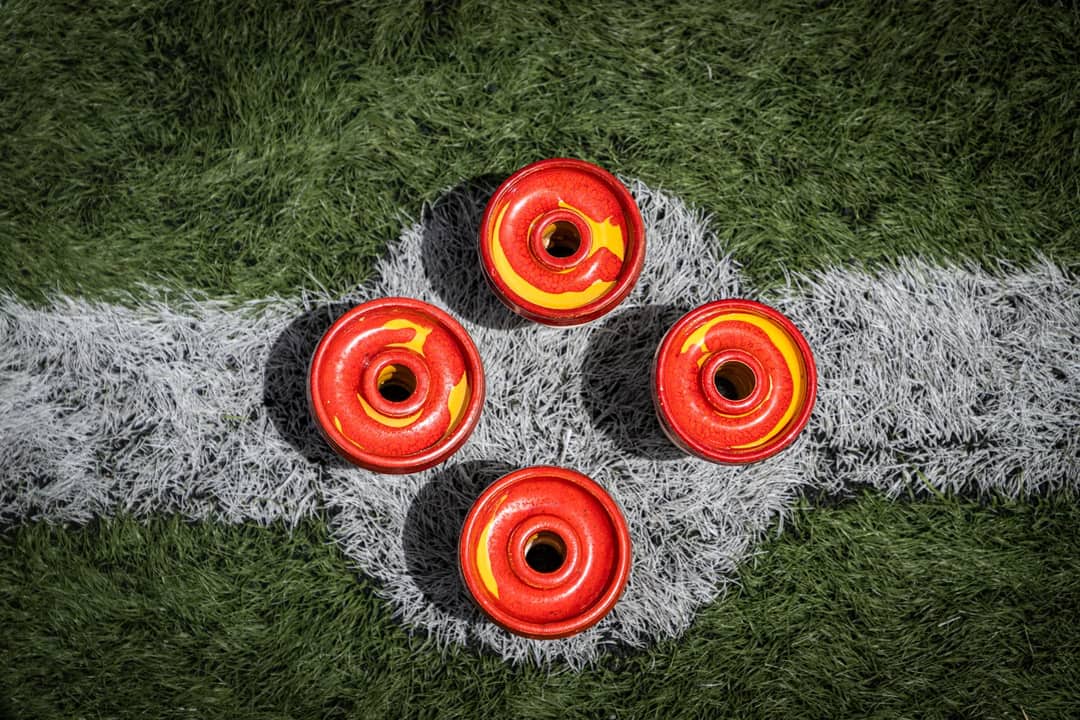 Red and yellow shisha bowls arranged on a white marked artificial grass field.