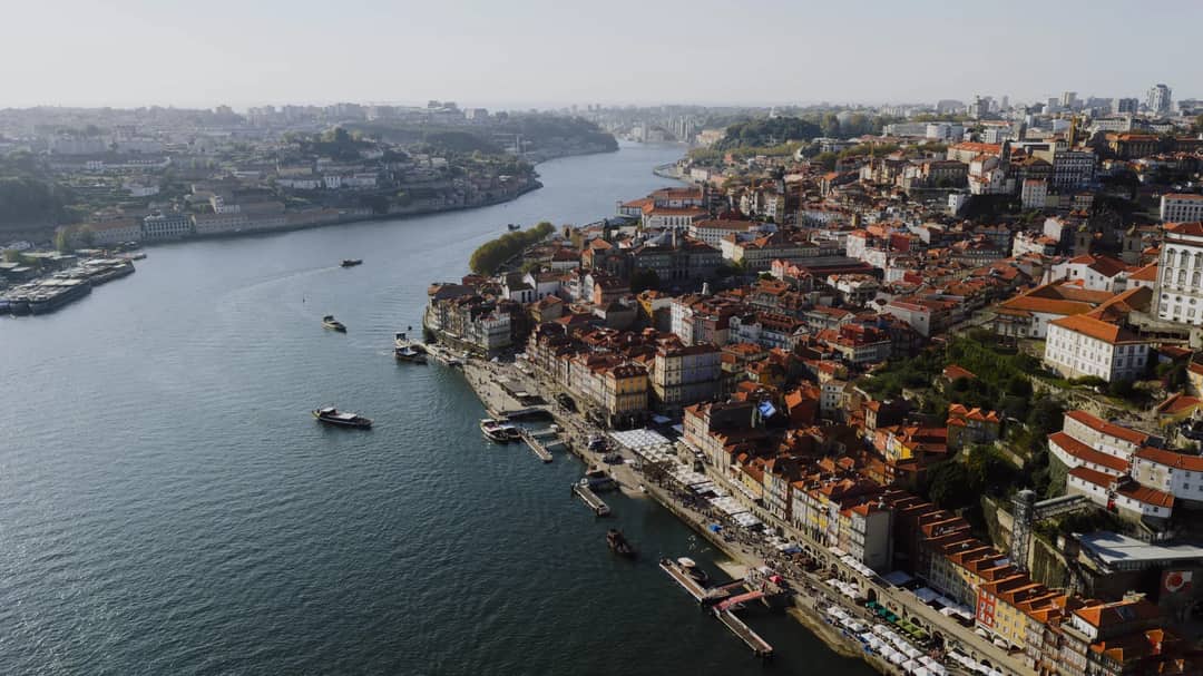Stunning aerial view of Porto, Portugal, showcasing the Douro River and historic cityscape under a clear sky.