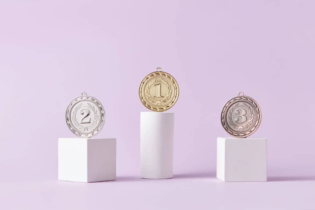 Medals on a podium against a soft pastel background, ideal for awards themes.