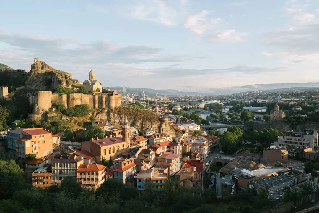 Stunning aerial view of Tbilisi featuring the historic Narikala Fortress and charming cityscape.