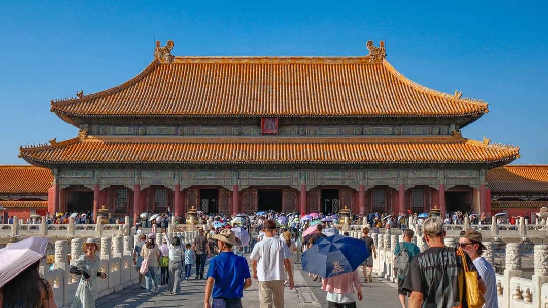 Tourists explore the Forbidden City in Beijing on a sunny day.