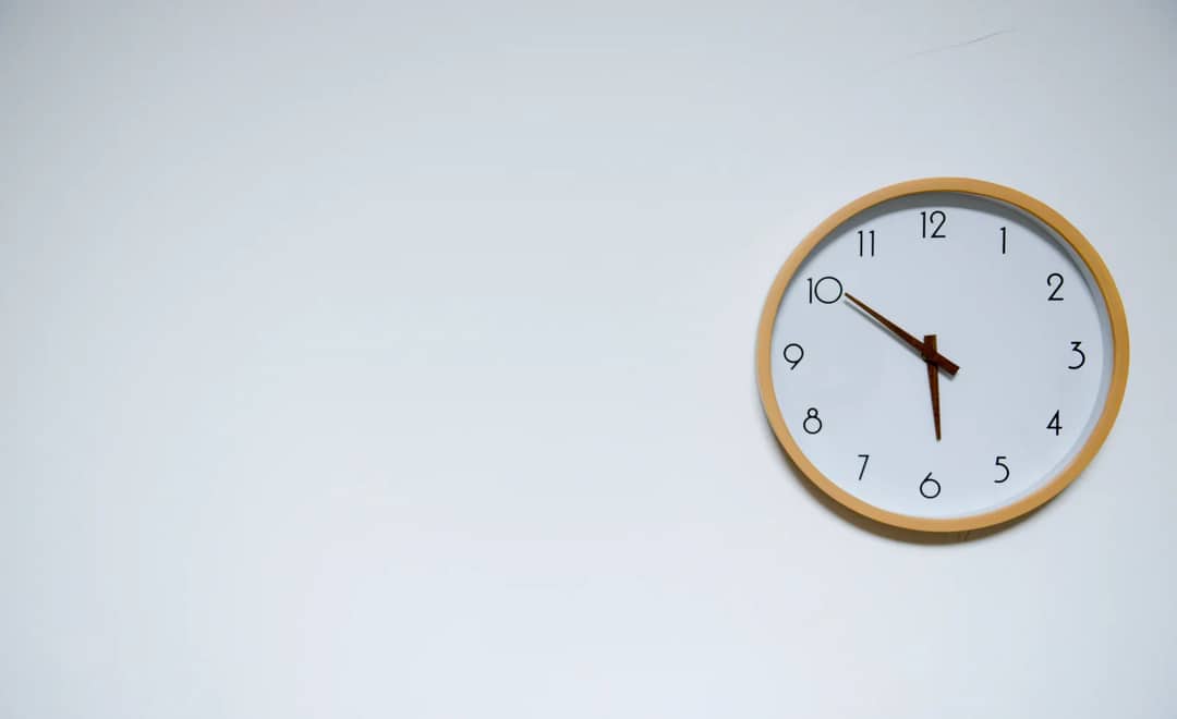 A round wall clock on a plain wall