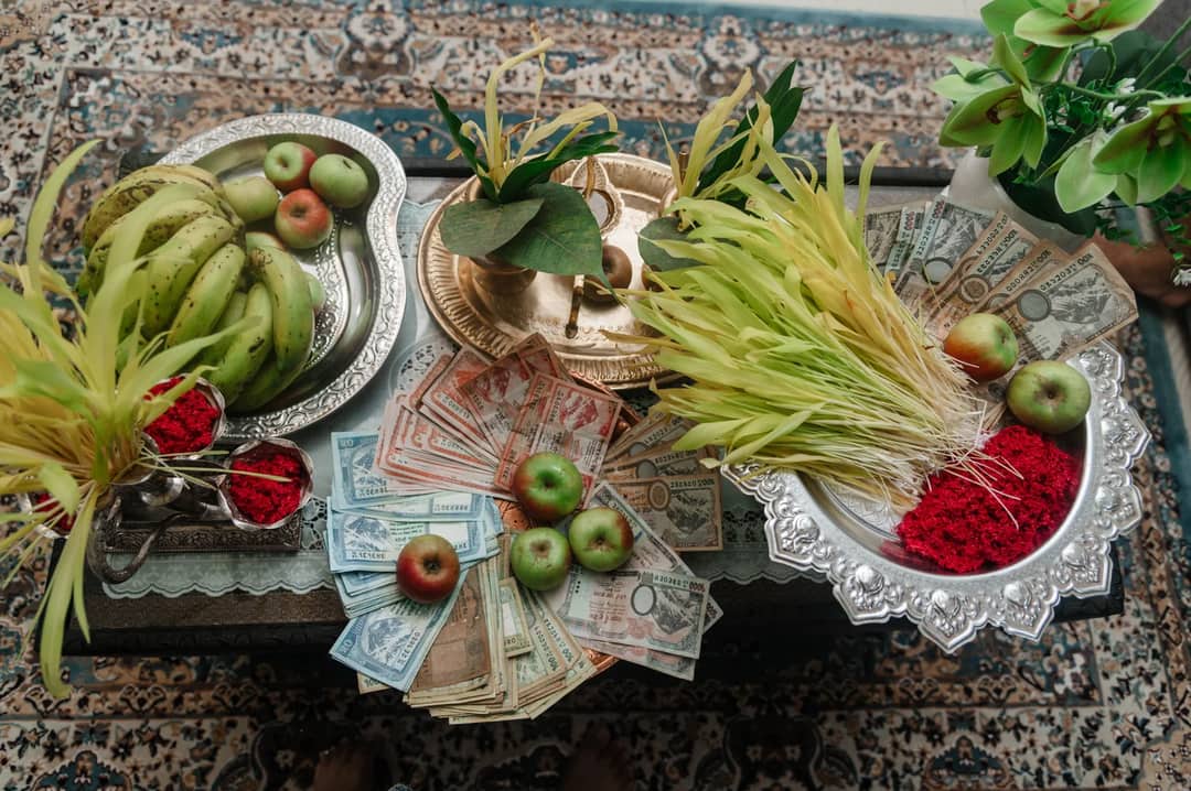 Top view of traditional Dashain offerings with fruits, money, and cultural elements on a table.