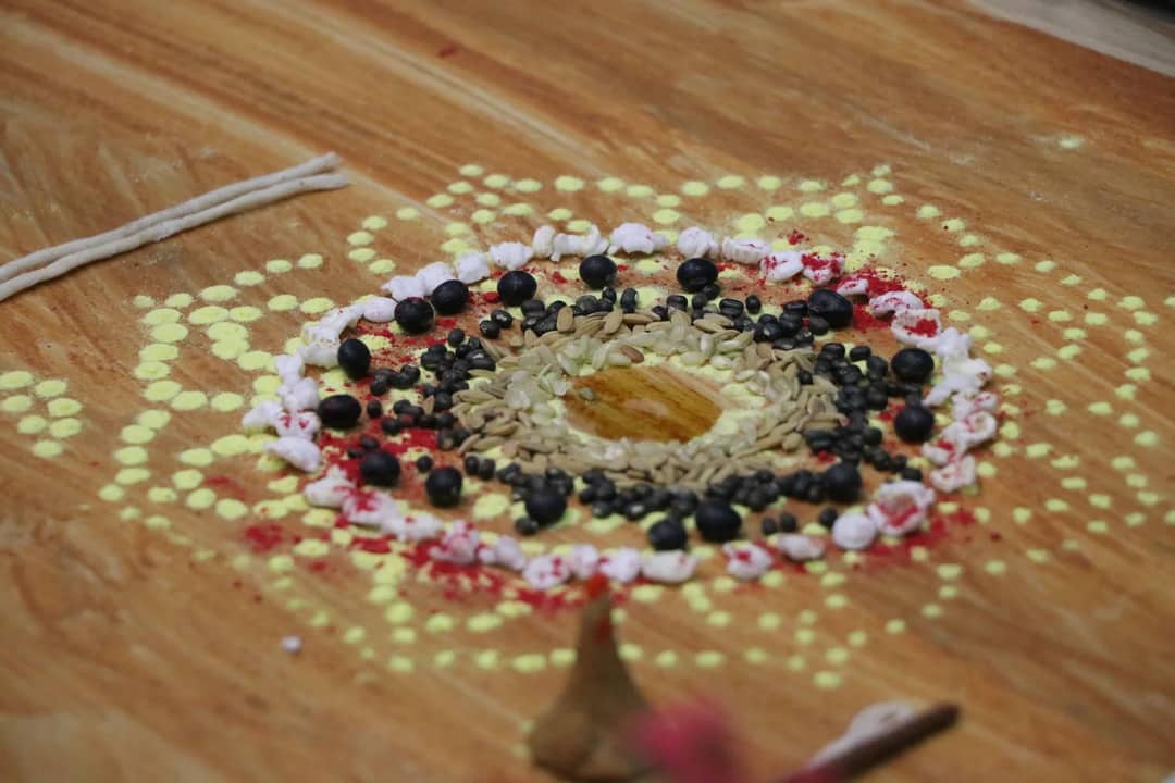 Colorful mandala with seeds and powders for Nepalese festive rituals symbolizing cultural richness.