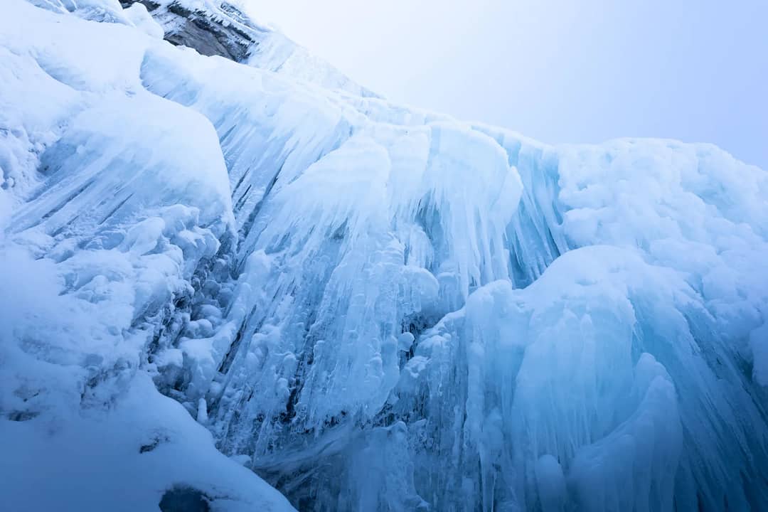 A stunning frozen waterfall showcasing intricate ice formations and icicles.