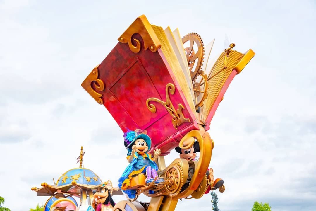 Vibrant Disney parade float featuring iconic characters with a large storybook theme.