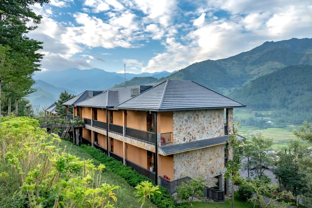 A lodge nestled amidst lush mountains with a picturesque rural view.