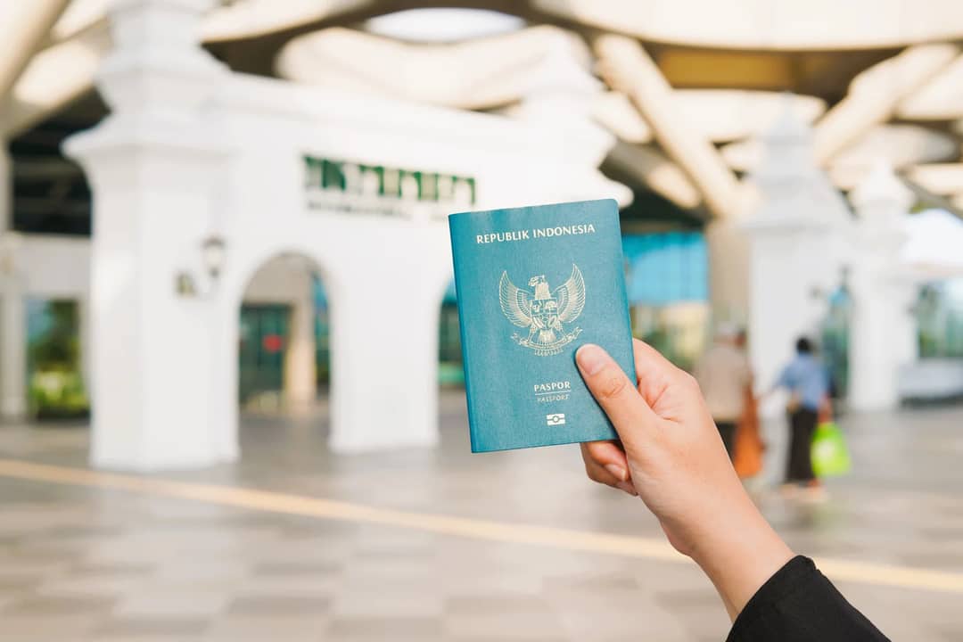 Close-up of a hand holding an Indonesian passport at Yogyakarta International Airport.