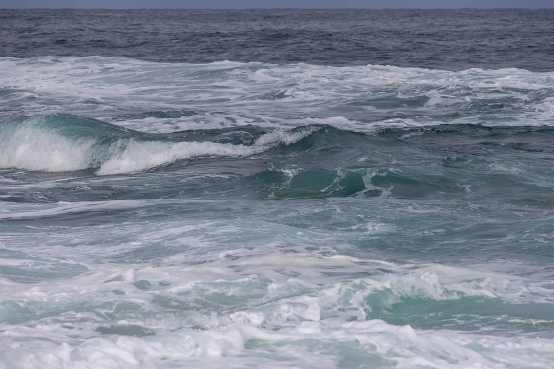 Dynamic image of ocean waves showcasing nature's power and beauty under a cloudy sky.