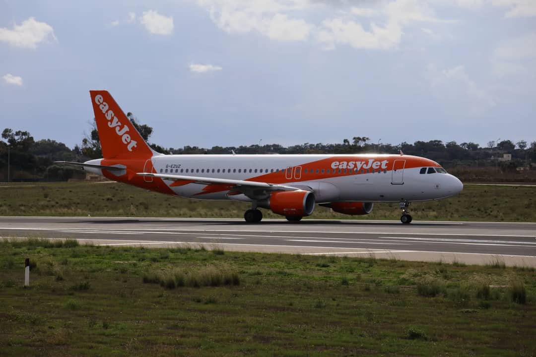 EasyJet Airbus A320 preparing for takeoff on a sunny day captured on runway.