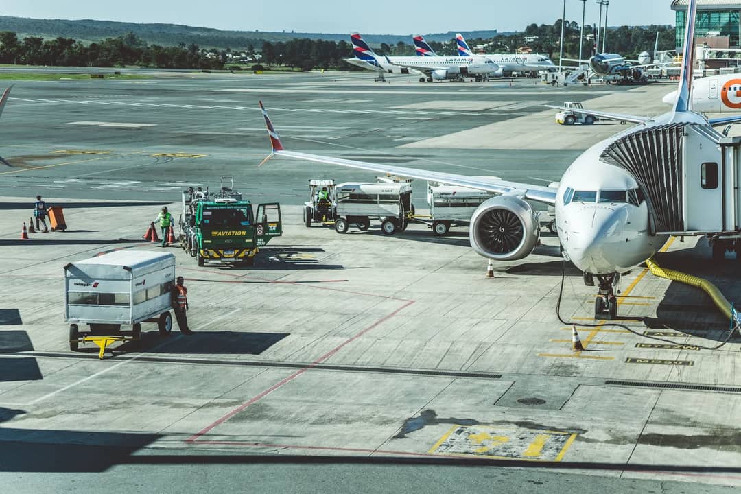 Ground crew preparing a commercial airplane for departure at an airport tarmac.