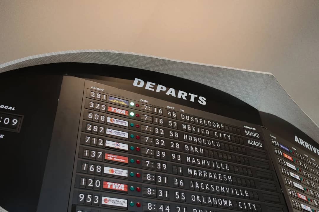 Close-up of airport departure board displaying flight details at JFK Airport, New York.