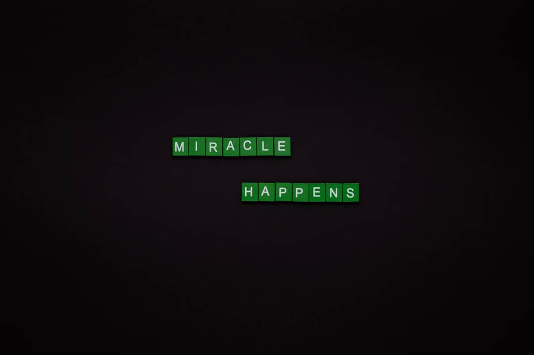 Motivational image featuring the words 'Miracle Happens' using green tiles on a black backdrop.