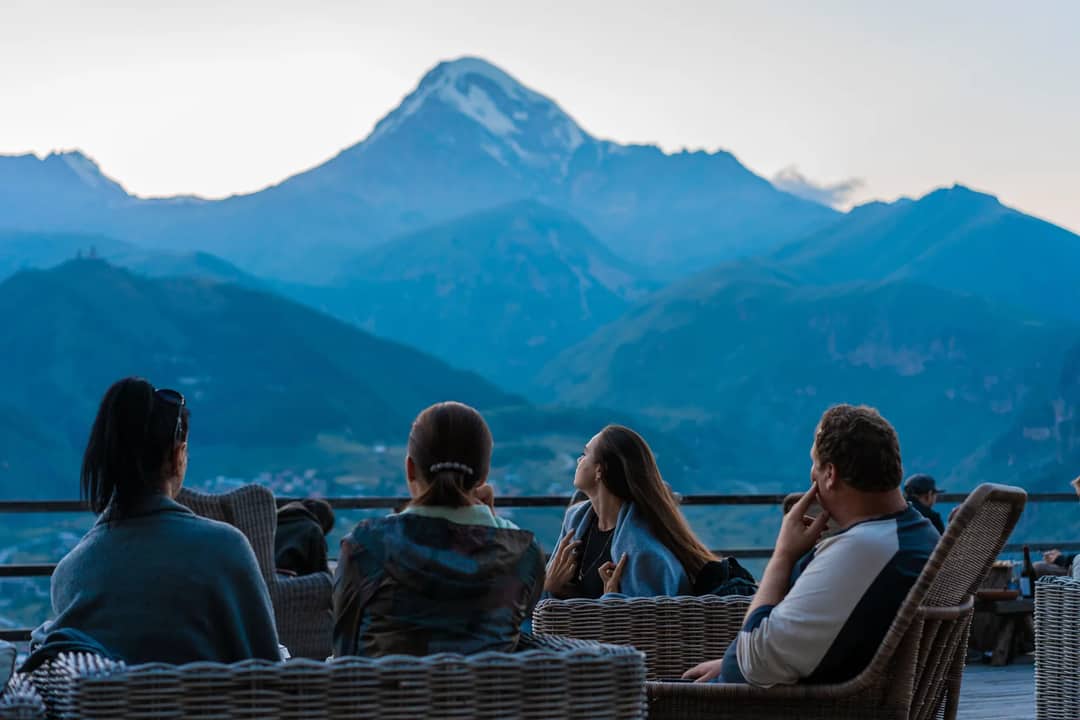 Relaxing group enjoying the scenic mountain view in Stepantsminda, Georgia.