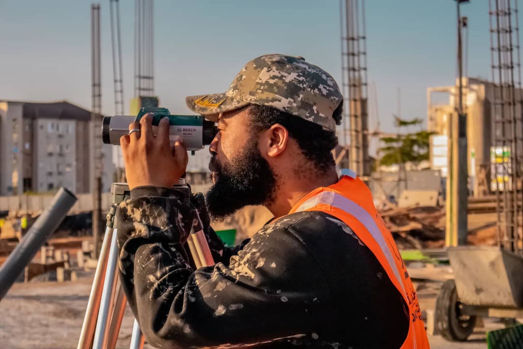 A surveyor sighting through an instrument