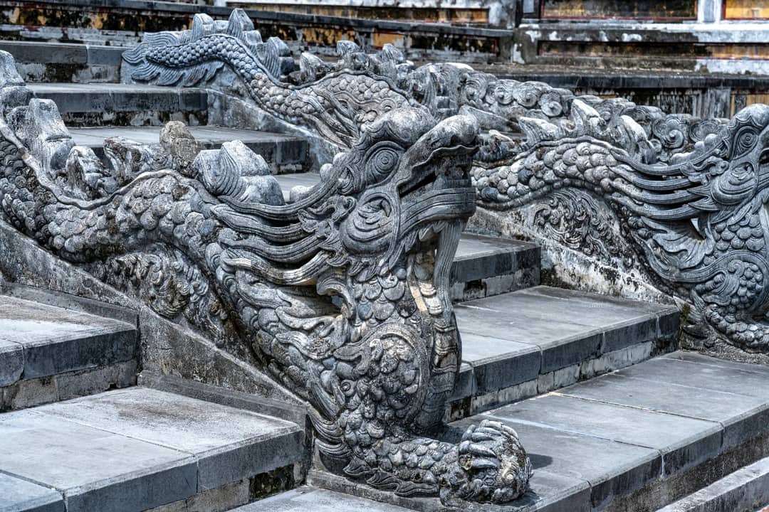 Detailed image of ornate stone dragon sculptures on ancient staircase, showcasing traditional Asian artistry.