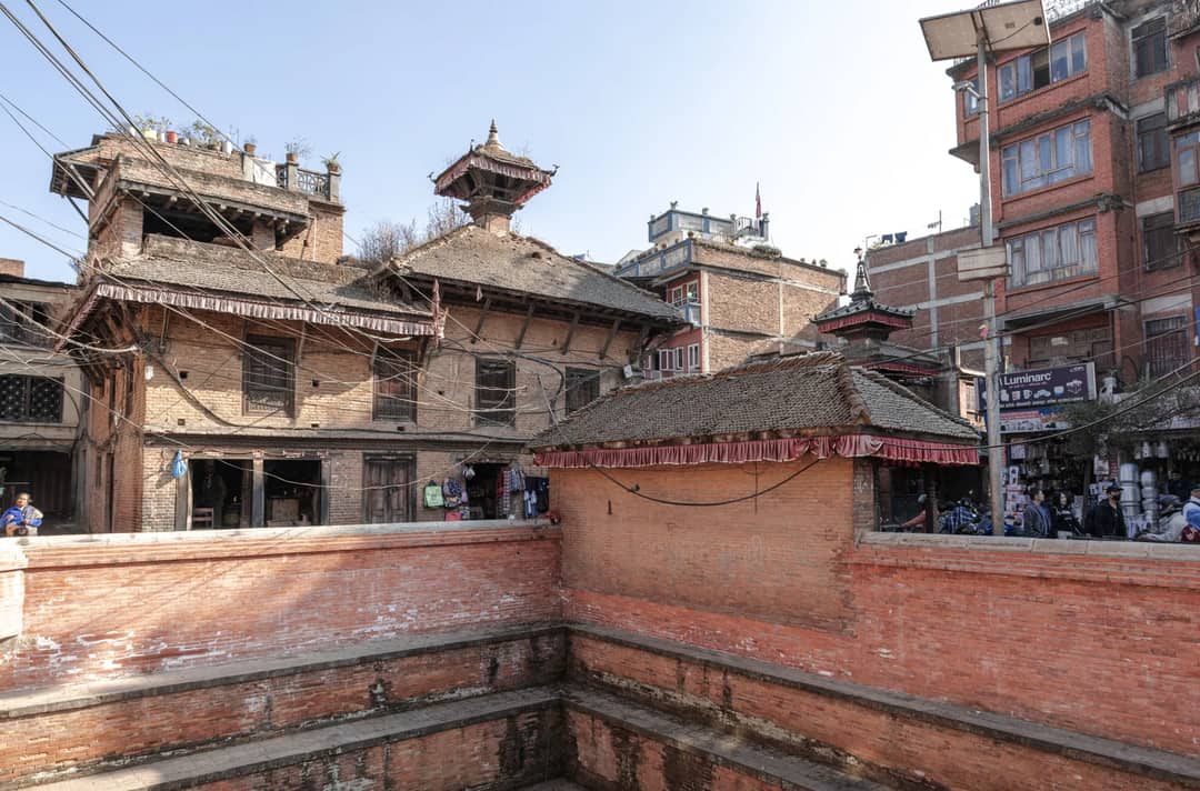 Historic brick buildings in Bhaktapur, Nepal's ancient cityscape under clear skies.