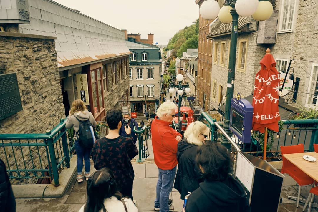 Tourists explore a historic street in Old Quebec, Canada, featuring charming architecture.