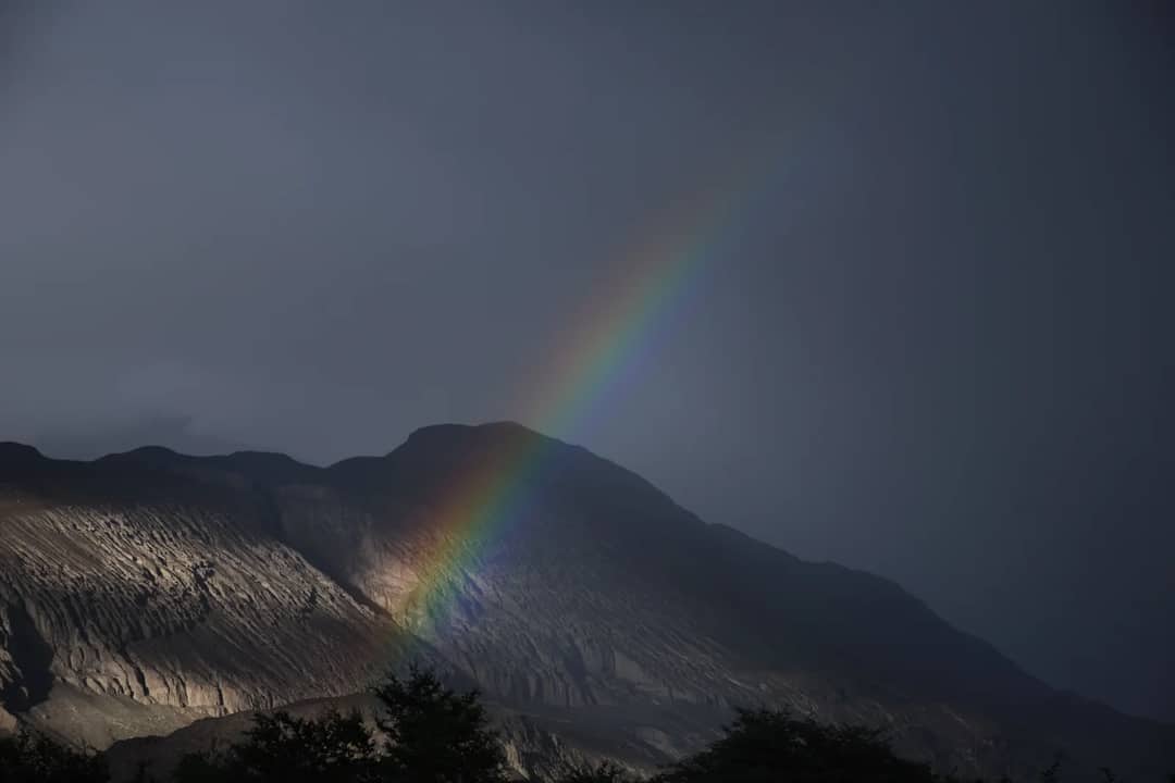 A stunning rainbow arches over a rugged mountain landscape in Diskit, capturing natural beauty and tranquility.