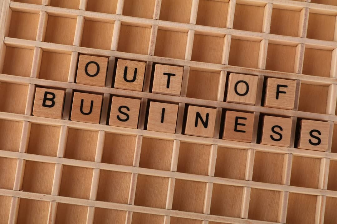 Wooden blocks spelling out 'Out Of Business' symbolize closure or economic downturn.