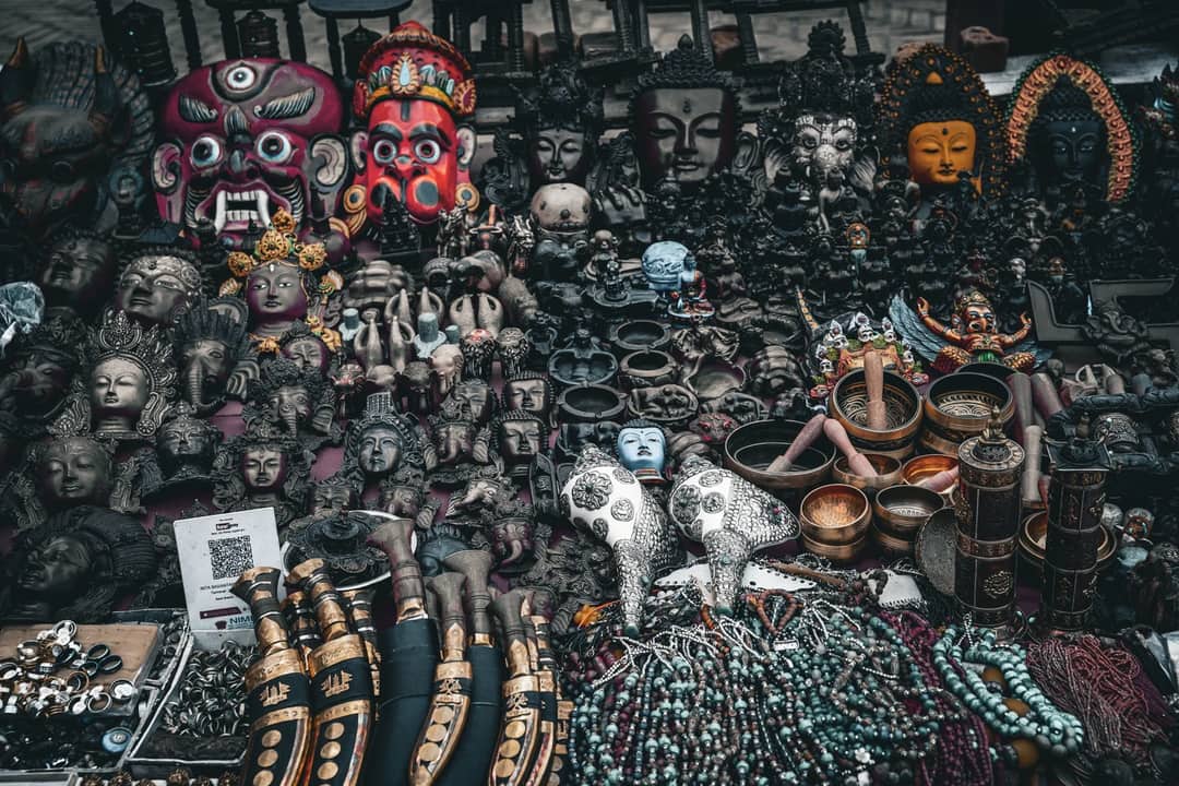 Intricate collection of cultural masks and artifacts on display at a traditional market.