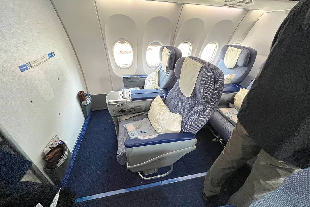 A wide-body airline business-class cabin with staggered lie-flat seats — how to book premium cabins for less in 2026