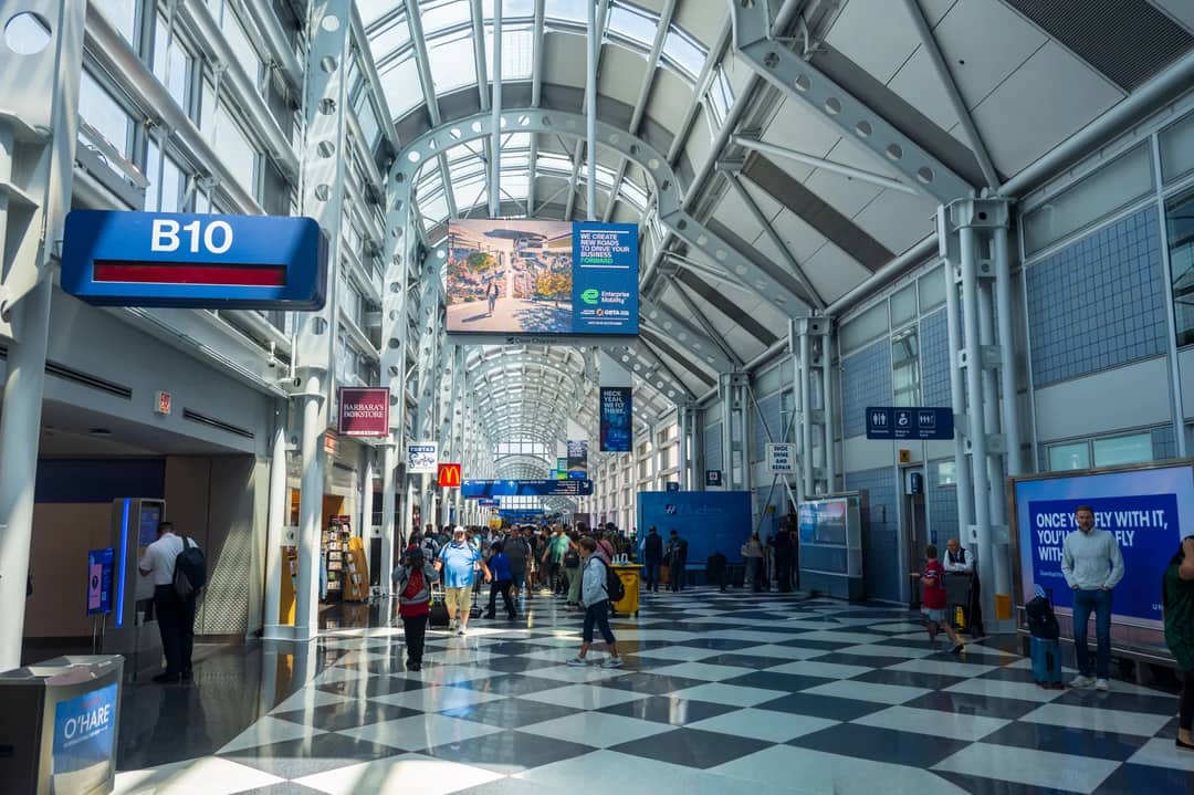 A busy terminal at O'Hare International Airport with travelers and architectural design.
